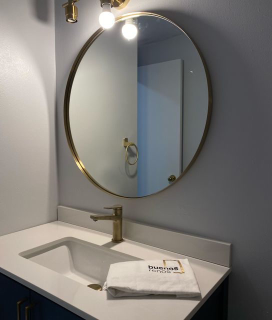 Contemporary bathroom vanity with circular gold
mirror and modern sink