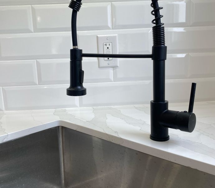 Sink and plumbing on black countertop